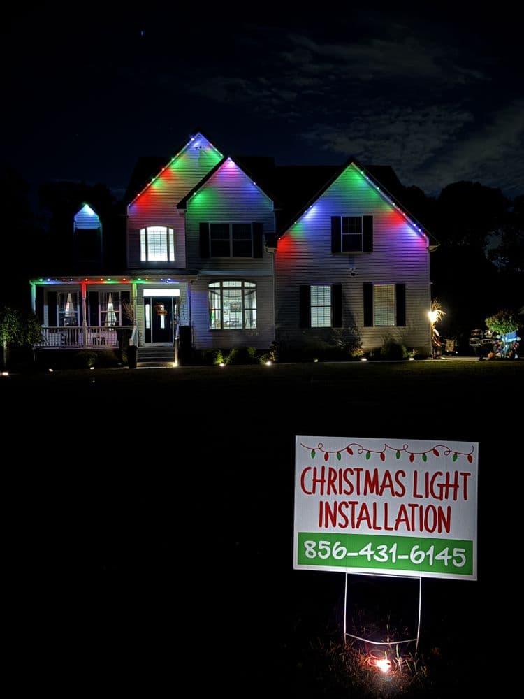 Christmas light installation on a beautifully decorated house at night, showcasing vibrant colors.
