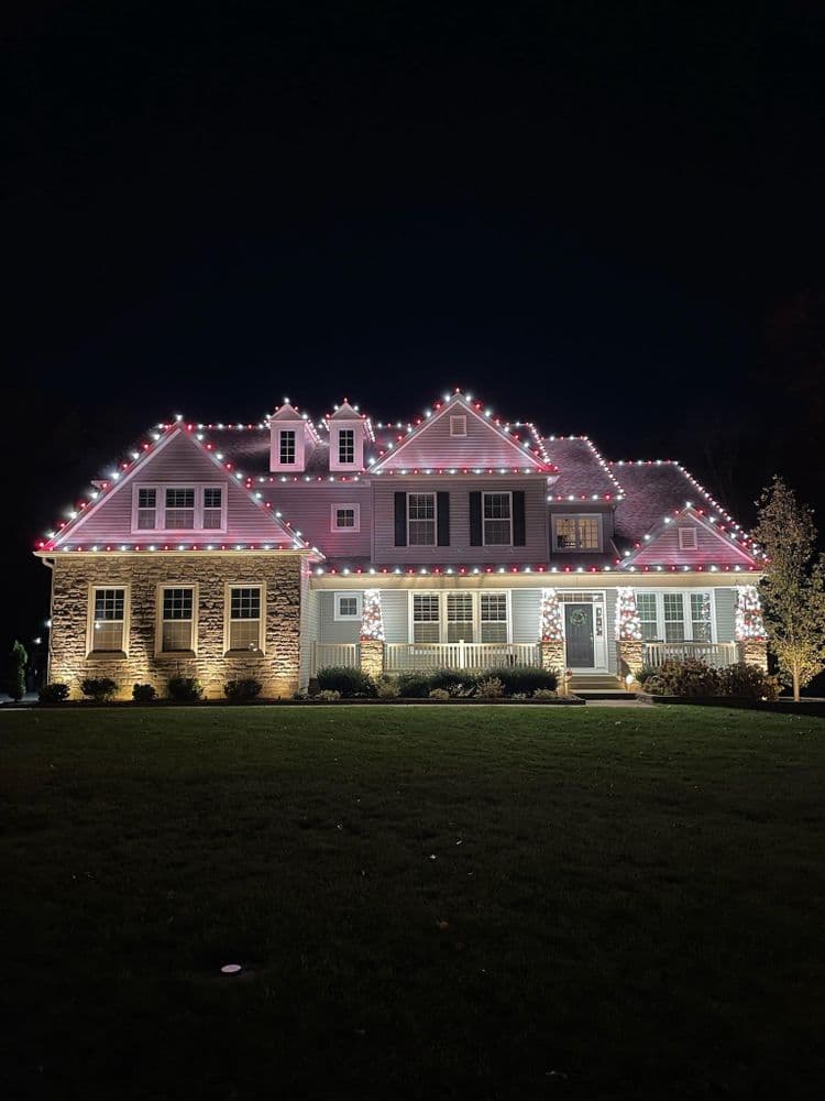 Festive house exterior adorned with colorful Christmas lights at night.