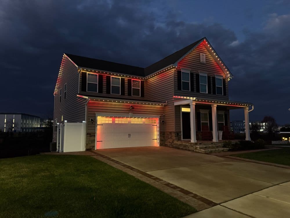 House adorned with colorful holiday lights at dusk, showcasing festive decorations.