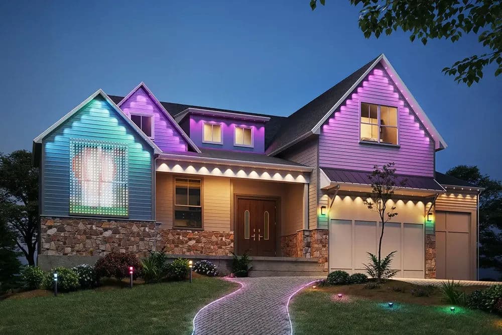 Modern house exterior with colorful LED lights and landscaped pathway at dusk.