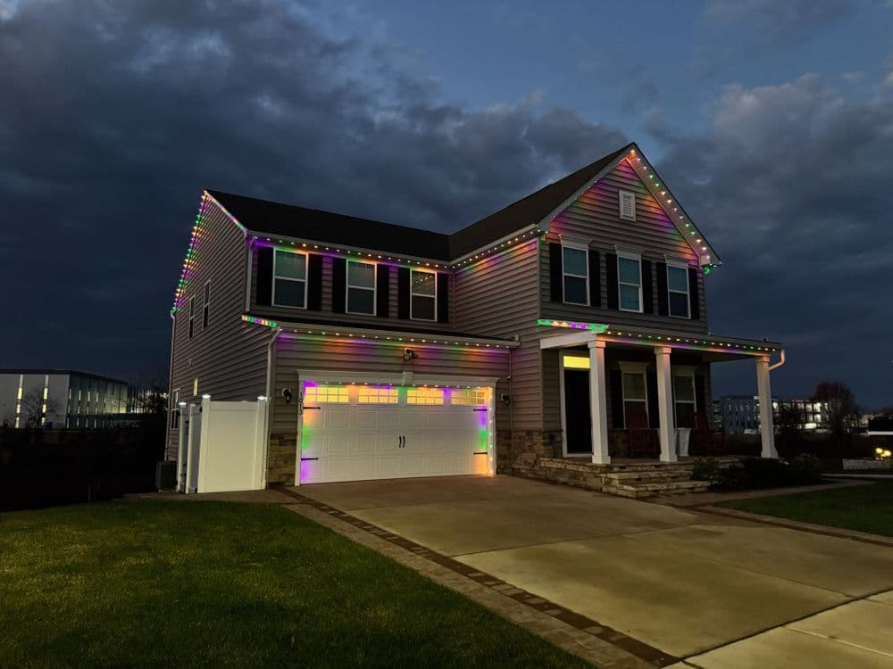 Modern house decorated with colorful holiday lights at dusk, showcasing festive spirit.