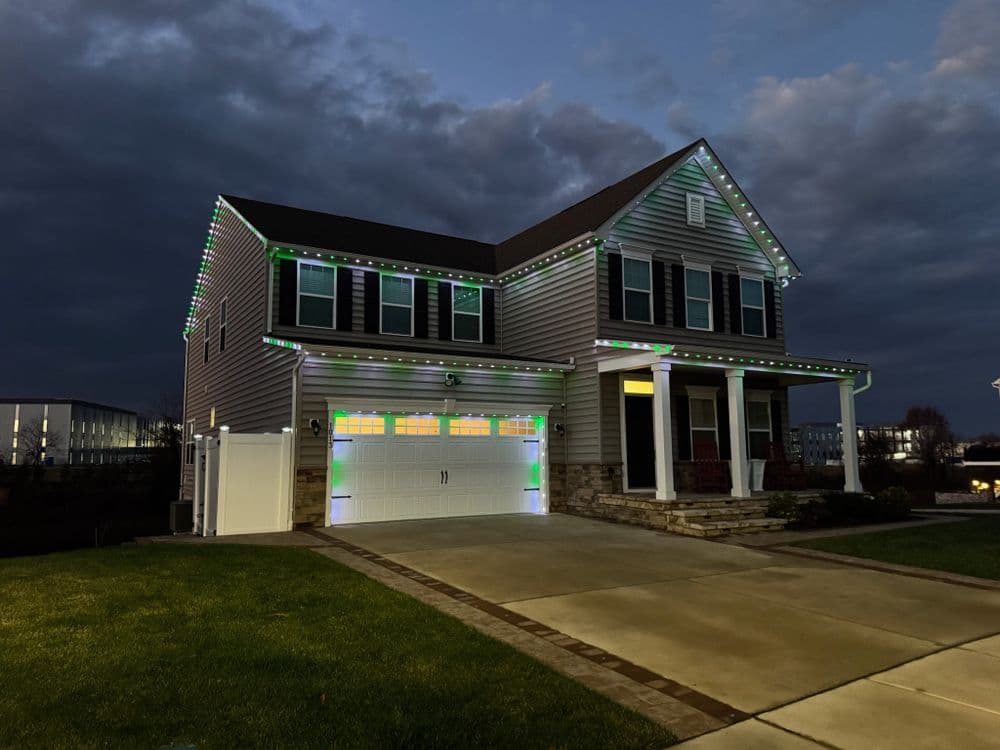 Modern house decorated with colorful LED lights for the holidays at dusk.