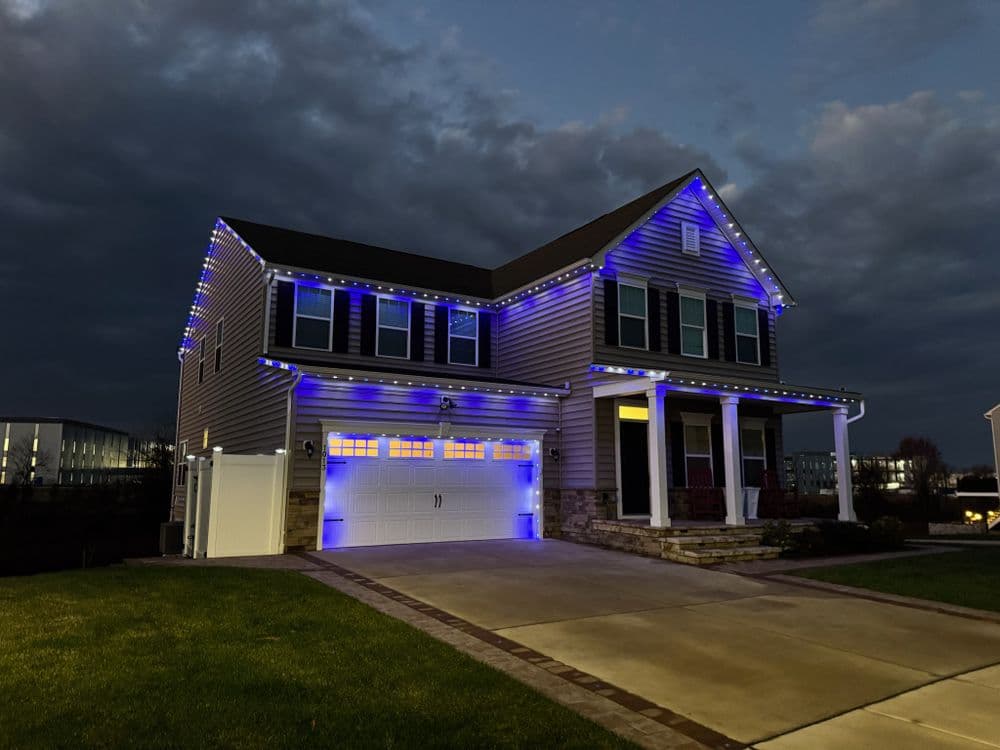 Home decorated with blue LED lights at dusk, showcasing a welcoming modern facade.